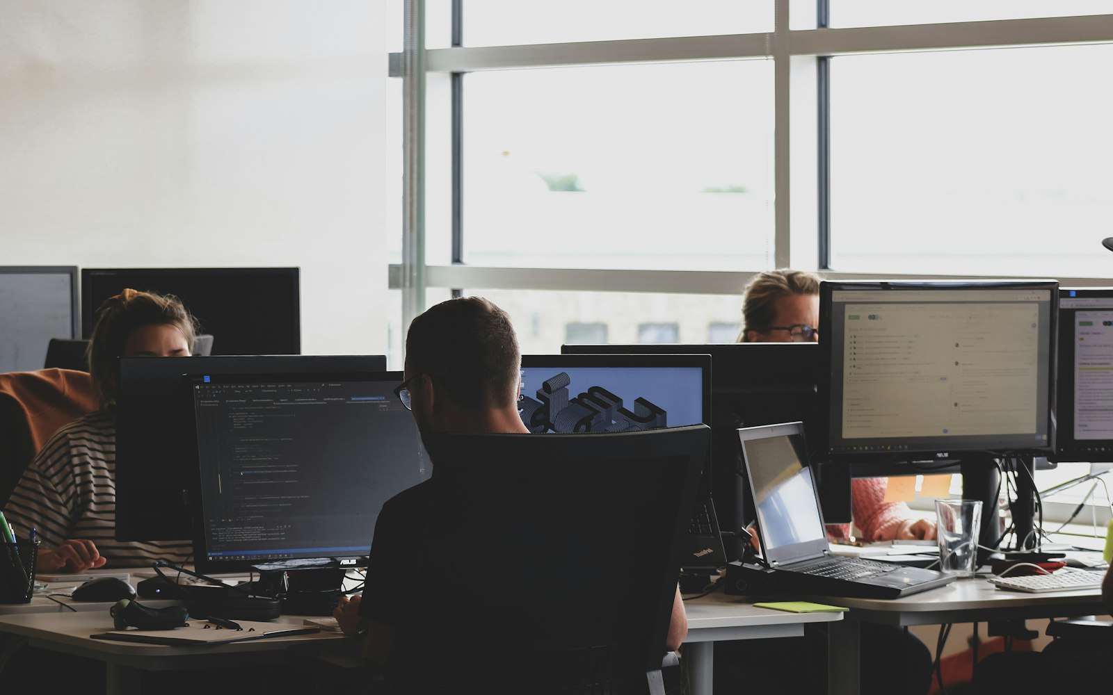 IT support staff working at computer monitors on a helpdesk