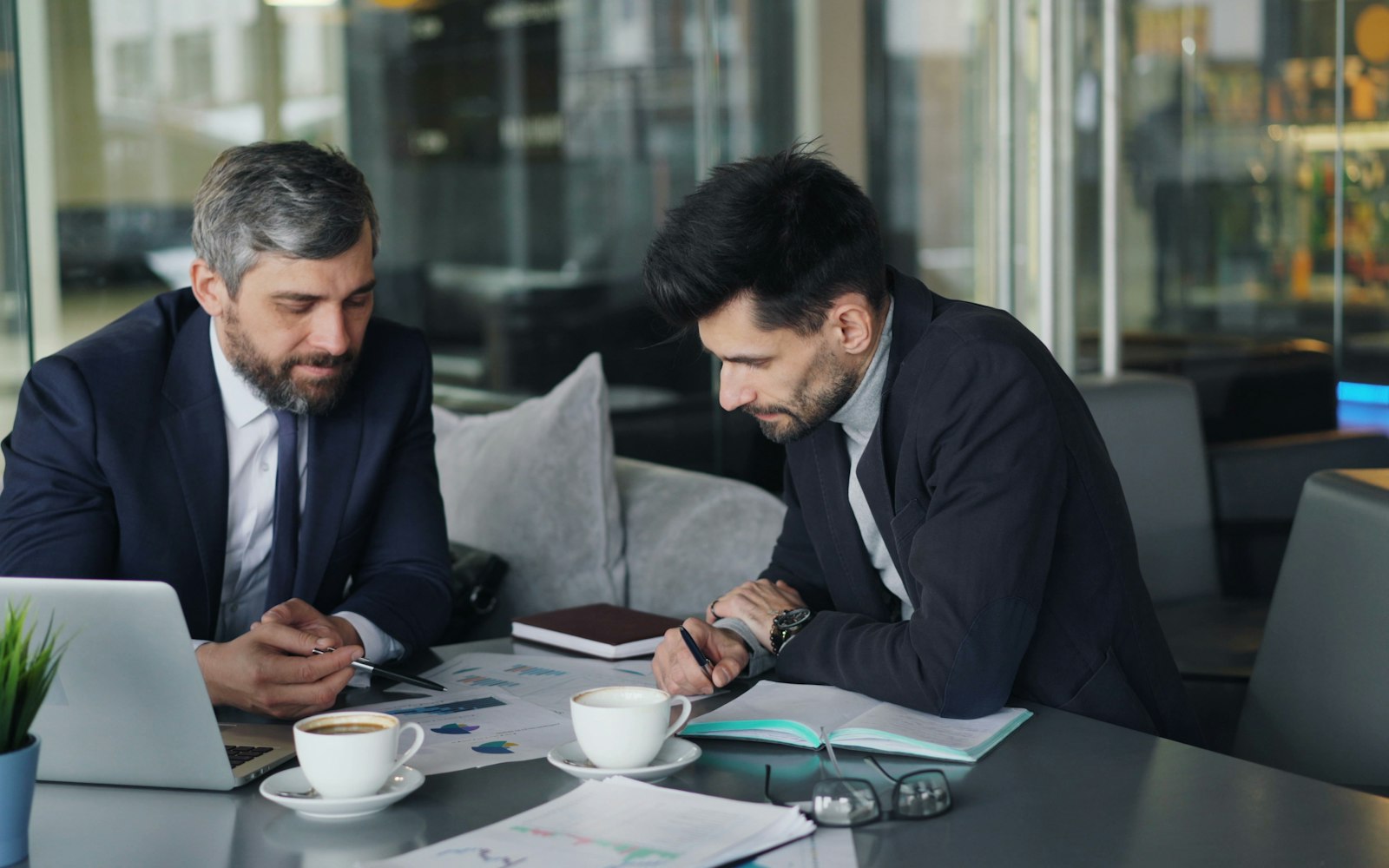 Two IT staff reviewing data access permissions on a laptop