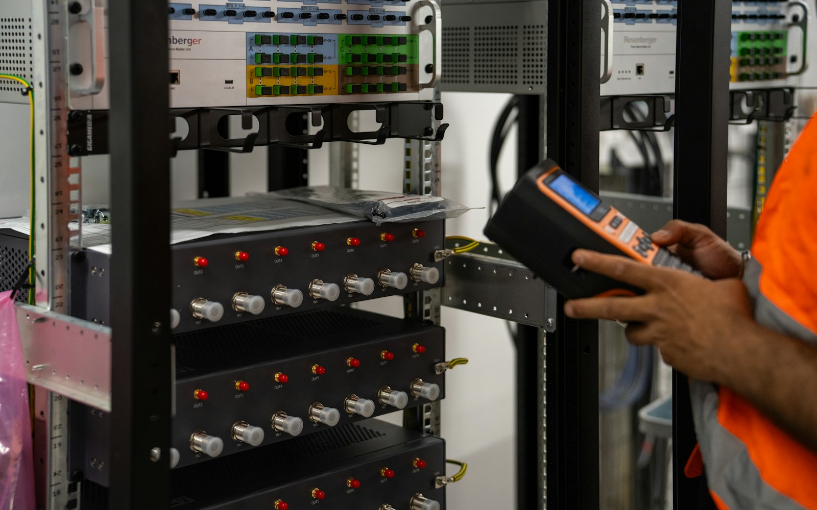 Technician inspecting server racks with a diagnostic tool