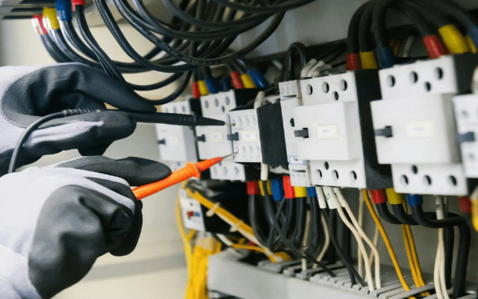 مهندس يختبر لوحة توزيع الطاقة بجهاز قياس متعدد